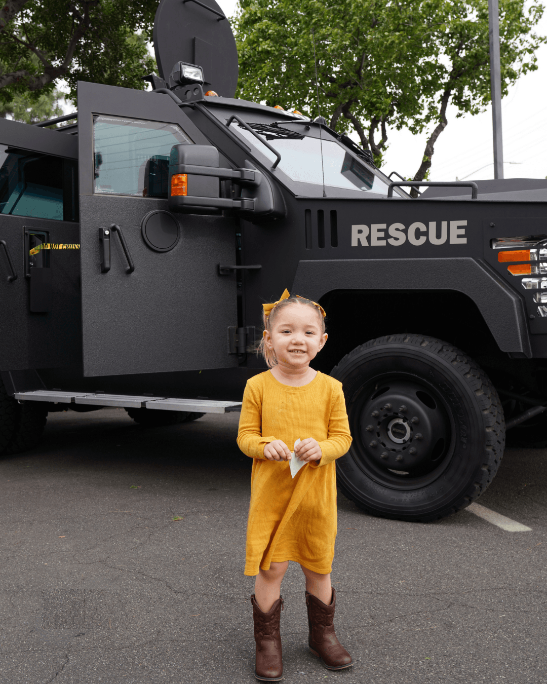 Child posing outside of a police department vehicle